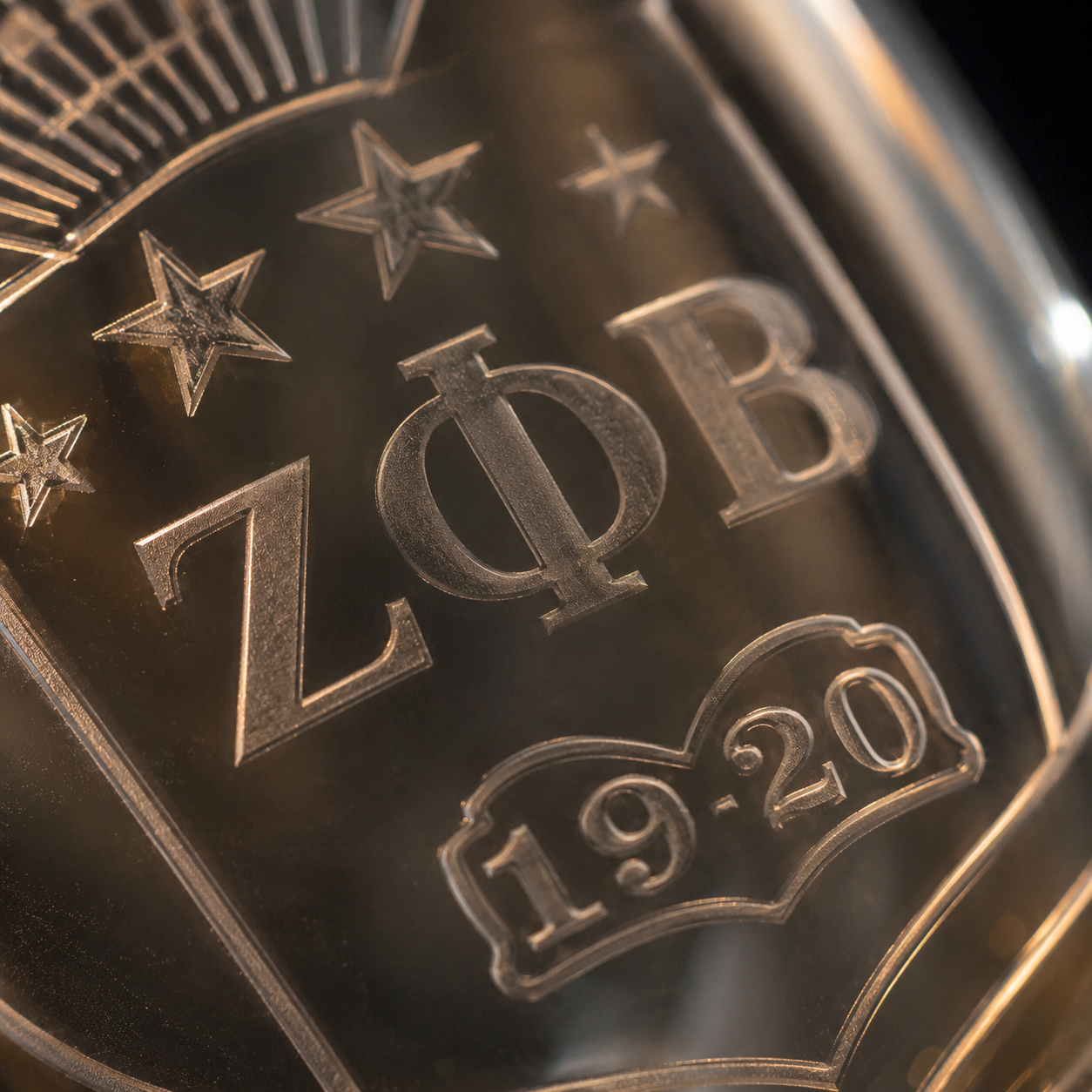 Macro detail of hand-etched ZΦB crest on glass